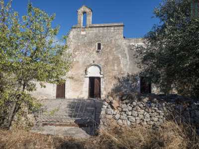 Il prospetto � aperto esclusivamente da tre porte rettangolari e da una finestrella collocata in alto. L�entrata centrale � sormontata da archivolto leggermente aggettante con lunetta semicircolare cieca